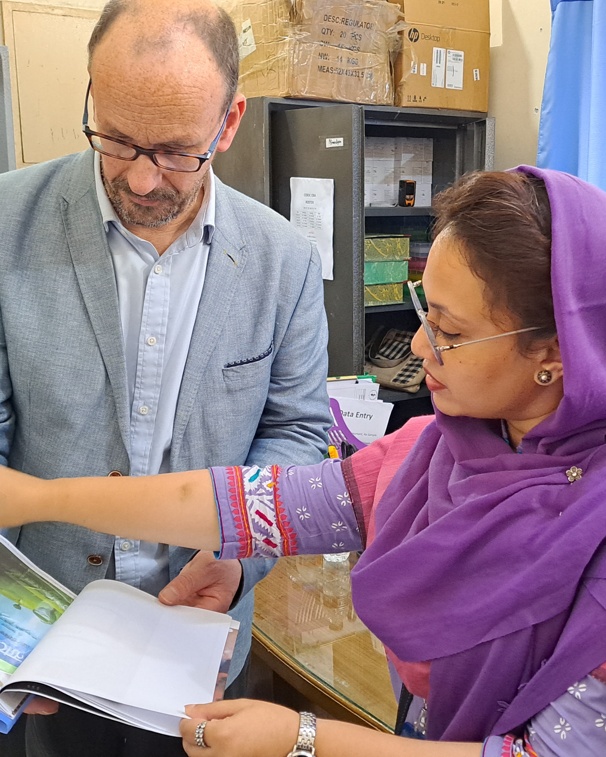 Professor Michael Eddleston reviewing documents with a female doctor in Bangladesh