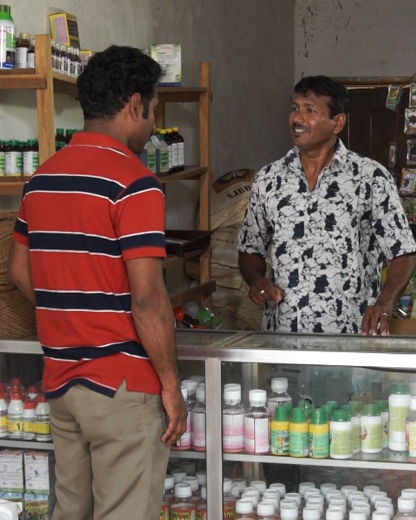 Pesticide vendor speaking to a customer in Sri Lanka